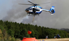 Des hélicoptères de la police chargent de l'eau pour lutter contre un incendie de forêt à Hurtgenwald, dans l'ouest de l'Allemagne, le 14 août 2026 ( AFP / Roberto Pfeil )