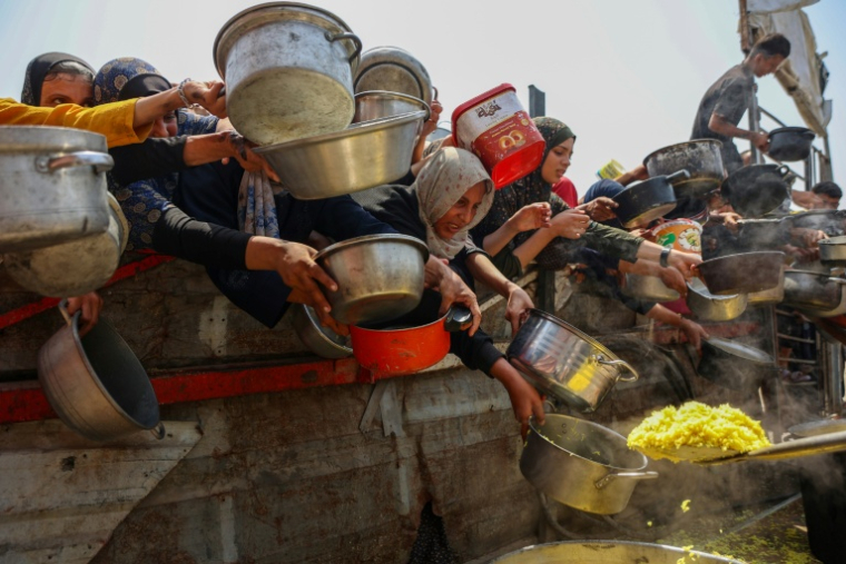 Des Palestiniens tentent de recevoir de la nourriture lors d'une distribution à Gaza le 13 août 2025 ( AFP / Omar AL-QATTAA )