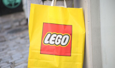 Une personne tient un sac Lego devant l'un des magasins de l'entreprise à Copenhague