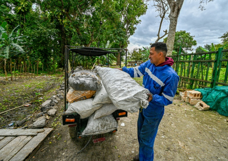 Yurisnel Agosto, un charbonnier de 36 ans, prépare des sacs de charbon de bois destinés à la vente sur une route de La Havane, le 6 février 2026 ( AFP / ADALBERTO ROQUE )