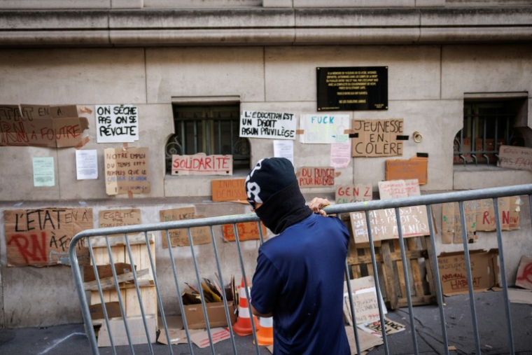 Un lycéen transporte une barrière devant le lycée Louis-le-Grand à Paris, le 2 octobre 2026 ( AFP / Simon WOHLFAHRT )