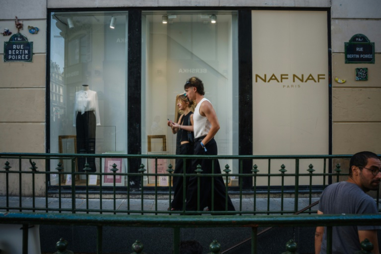 Des personnes passent devant une boutique Naf Naf à Paris le 6 août 2025 ( AFP / Dimitar DILKOFF )