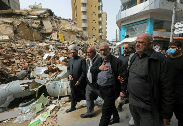Un responsable du mouvement pro-iranien Hezbollah, Mahmoud Qamati (C)inspecte les destructions cusées par les frappes israéliennes dans la banlieue sud de Beyrouth, le 18 avril 2026 ( AFP / ibrahim AMRO )