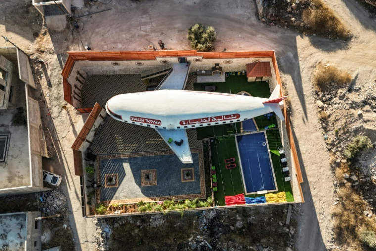 Plan aérien d'un gîte touristique construit en forme d'avion à Qaffin, dans le nord de la Cisjordanie occupée, le 2 juillet 2025 ( AFP / John WESSELS )