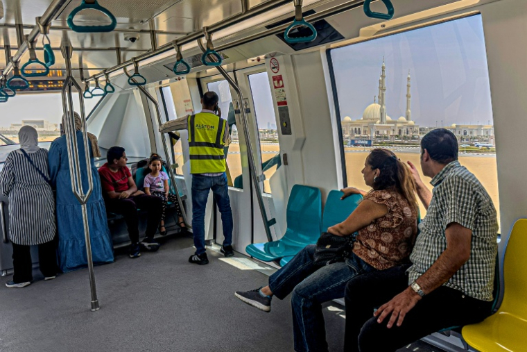 Des passagers à bord du monorail récemment inauguré près de la grande mosquée al-Fattah al-Alim  dans la nouvelle capitale administrative, à l'est du Caire, le 22 mai 2026, en Egypte ( AFP / Khaled DESOUKI )