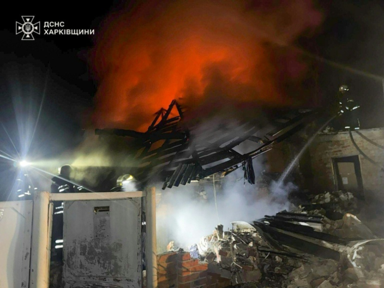 Photographie publiée par les services de secours ukrainiens montrant des pompiers luttant contre un incendie après une frappe de drone russe qui a tué un père et ses trois enfants dans une maison à Bogodoukhiv le 11 février 2026 ( Ukrainian State Emergency Service / Handout )