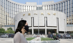 Une femme passe devant le siège de la Banque populaire de Chine (PBOC), la banque centrale, à Pékin
