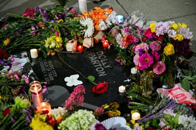 Des fleurs et des bougies, déposées par des fans, recouvrent l'étoile de la chanteuse et compositrice américaine Dolly Parton sur le "Music City Walk of Fame" de Nashville, dans le Tennessee, le 25 août 2026 ( AFP / CHANDAN KHANNA )