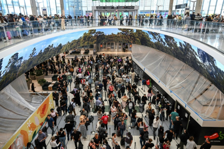 Des voyageurs patientent dans de longues files d'attente aux contrôles de sécurité de l'aéroport intercontinental George Bush de Houston, au Texas, le 23 mars 2026 ( AFP / RONALDO SCHEMIDT )