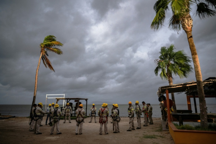 Des employés de la compagnie d'électricité réunis sur la plage de Puerto San Carlos, au Mexique, avant l'arrivée de l'ouragan Polo, le 28 septembre 2026 ( AFP / Carl de Souza )