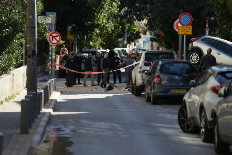Des policiers sur les lieux d'un tir de missile iranien, le 8 mars 2026 à Tel-Aviv  ( AFP / Ilia YEFIMOVICH )
