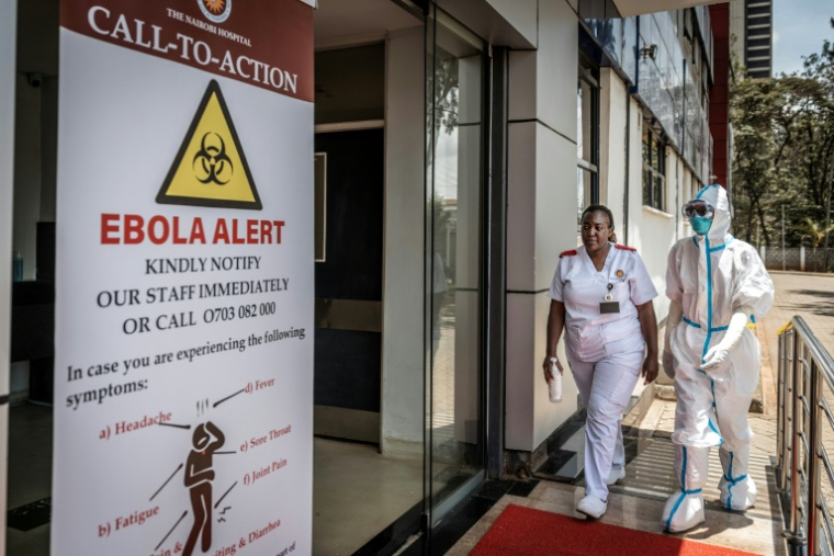 Des infirmières dans une unité d’isolement signalée par un panneau d’alerte Ebola, à l’hôpital de Nairobi, le 7 octobre 2026 au Kenya ( AFP / Luis TATO )