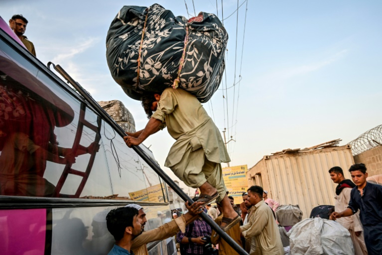 Des réfugiés afghans, expulsés du Pakistan, chargent leurs affaires dans un bus à Karachi, le 8 avril 2025, avant leur départ pour l'Afghanistan ( AFP / Asif HASSAN )