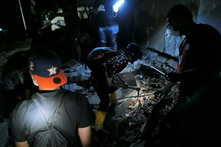 Des secouristes recherchent des victimes dans les décombres d'un immeuble effondré après deux séismes à Caraballeda, dans l'Etat de La Guaira, le 27 juin 2026 au Venezuela ( AFP / Mauricio VALENZUELA )