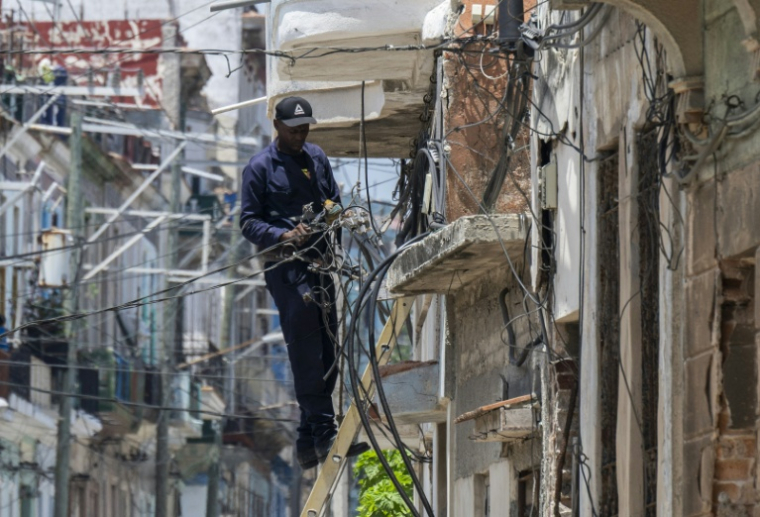 Un ouvrier intervient sur le réseau électrique, le 6 juillet 2026 à La Havane, lors d'une panne de courant nationale à Cuba ( AFP / YAMIL LAGE )