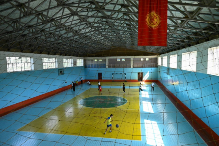 Des enfants jouent dans une nouvelle salle de sport, construite grâce au financement des émigrants kirghizes à l'étranger, dans le village de Kyzyl-Jol, le 21 mai 2025 au Kirghizstan ( AFP / Guliza Urustambek kyzy )
