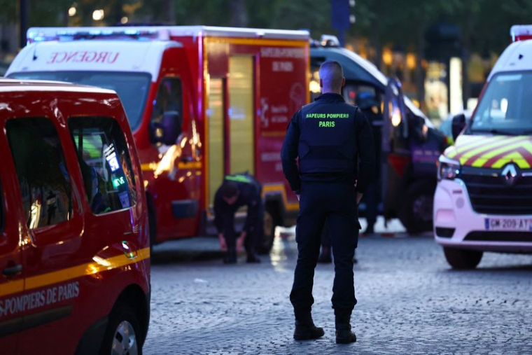 Le personnel d'urgence travaille sur l'avenue des Champs Elysées après un incident de sécurité rapporté par les médias locaux, à Paris, France.