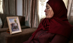 Milia Hamayel, dont le fils Thaer Hamayel a été tué lors d'une attaque de colons israéliens, regarde une photo de son fils défunt dans son village de Abou Falah, au nord-est de Ramallah, le 12 mars 2026 ( AFP / Zain JAAFAR )