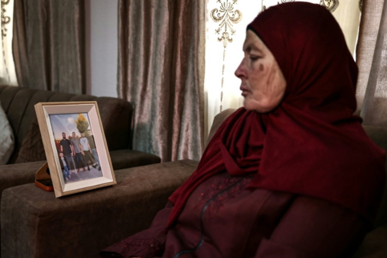 Milia Hamayel, dont le fils Thaer Hamayel a été tué lors d'une attaque de colons israéliens, regarde une photo de son fils défunt dans son village de Abou Falah, au nord-est de Ramallah, le 12 mars 2026 ( AFP / Zain JAAFAR )