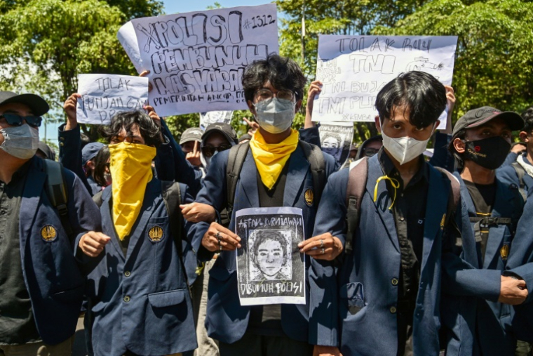 Un manifestant tient le portrait d'Affan Kurniawan, un taxi-moto écrasé par un véhicule de police dont la mort a provoqué des manifestations dans toute l'Indonésie, le 30 août 2025 à Surabaya, sur l'île de Java ( AFP / JUNI KRISWANTO )