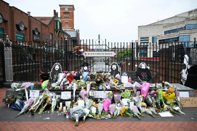 Des fleurs, des bougies et des dessins déposés sur le pont Black Sabbath, en hommage à l'auteur-compositeur-interprète britannique Ozzy Osbourne, au lendemain de sa mort, le 23 juillet 2025 à Birmingham, dans le centre de l'Angleterre ( AFP / JUSTIN TALLIS )