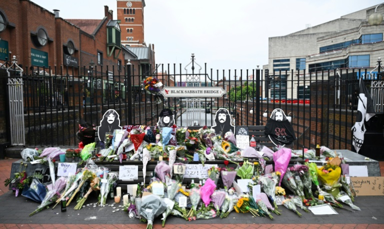 Des fleurs, des bougies et des dessins déposés sur le pont Black Sabbath, en hommage à l'auteur-compositeur-interprète britannique Ozzy Osbourne, au lendemain de sa mort, le 23 juillet 2025 à Birmingham, dans le centre de l'Angleterre ( AFP / JUSTIN TALLIS )
