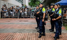 Des policiers se tiennent près de l'espace réservé aux médias devant les tribunaux de première instance de West Kowloon, avant le verdict du procès pour atteinte à la sécurité nationale de deux militants prodémocratie de la mémoire de Tiananmen, à Hong Kong, le 21 août 2026 ( AFP / Leung Man Hei )