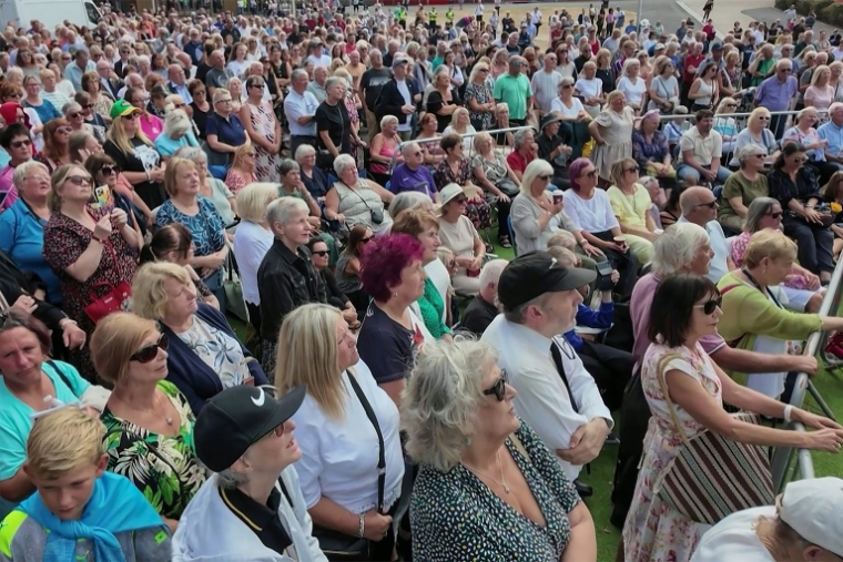Image tirée d'une vidéo AFP montrant la foule aassistant ux funérailles de la chanteuse Bonnie Tyler à Swansea, au Pays de Galles, le 17 août 2026 ( AFPTV / Lidia PEDRO )