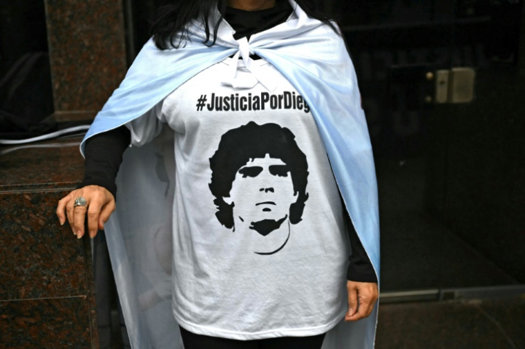 Un fan de Diego Maradona porte un t-shirt à l'image de son idole devant le tribunal de San Isidro, en Argentine, le 9 juin 2026 ( AFP / Luis ROBAYO )