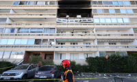 Un pompier passe devant la façade calcinée d'un immeuble suite à l'explosion d'une bouteille de gaz, dans le quartier des Minguettes à Vénissieux, dans la banlieue sud de Lyon, le 18 août 2025 ( AFP / Alex MARTIN )