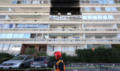 Un pompier passe devant la façade calcinée d'un immeuble suite de l'explosion d'une bouteille de gaz, dans le quartier des Minguettes à Vénissieux, dans la banlieue sud de la ville de Lyon, le 18 août 2025 ( AFP / Alex MARTIN )