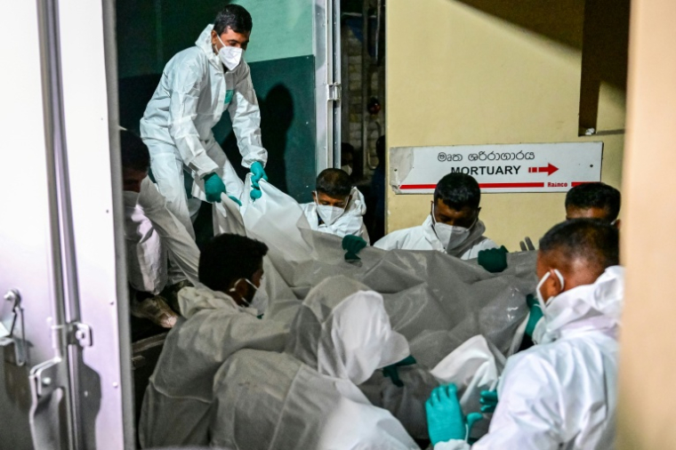 Des soignants transportent à la morgue de l'hôpital Karapitiya de Galle les corps de marins iraniens morts dans une attaque à la torpille américaine contre leur frégate IRIS Dena, au large des côtes du Sri Lanka, le 4 mars 2026 ( AFP / Ishara S. KODIKARA )