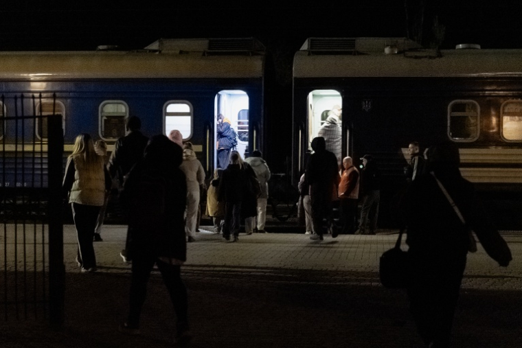 Des passagers regagnent le train de la ligne Kharkiv-Kiev après avoir été évacués en raison de la menace d’un drone russe, le 21 octobre 2026, dans le contexte de l’invasion russe de l’Ukraine.  ( AFP / Tetiana DZHAFAROVA )