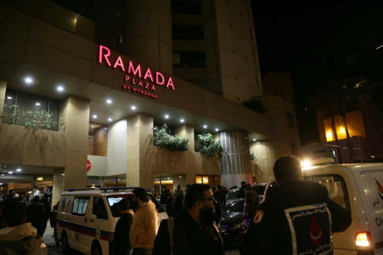 Des secouristes devant l'hôtel Ramada touché par une frappe israélienne, le 8 mars 2026 à Beyrouth  ( AFP / IBRAHIM AMRO )
