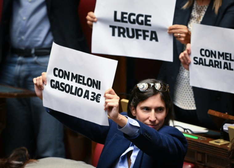 La secrétaire du Parti démocrate, Elly Schlein, brandit une pancarte "Avec Meloni, l'essence à 3 euros" dans la Chambre des députés, à Rome, le 8 octobre 2026 ( AFP / Tiziana FABI )