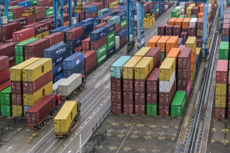 Des camions passent devant des conteneurs au port de Ningbo-Zhoushan, dans la province orientale du Zhejiang, le 28 mai 2025 en Chine ( AFP / Hector RETAMAL )
