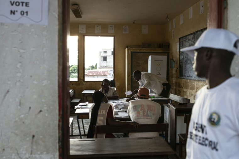Des employés de la Direction générale des élections de Guinée (DGE) procèdent au comptage des voix le 21 septembre 2025 d'un bureau de vote situé dans l'école primaire de Taouyah, dans la capitale Conakry. Quatre ans après la prise de pouvoir des militaires, la junte a soumis au vote un projet de nouvelle Constitution  ( AFP / PATRICK MEINHARDT )