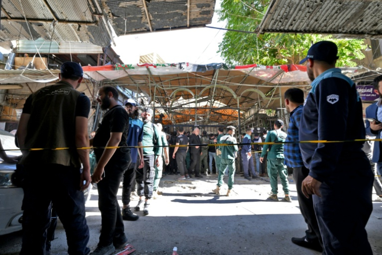 Les forces de sécurité syriennes et des passants sont rassemblés sur les lieux d'une explosion survenue dans un café de la capitale, Damas, le 2 juillet 2026 ( AFP / LOUAI BESHARA  )