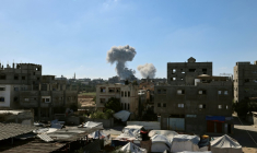 De la fumée s'élève en arrière-plan lors d'une frappe israélienne dans le centre de la bande de Gaza, le 29 mai 2025 ( AFP / Eyad BABA )