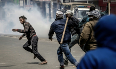 Des hommes armés de bâtons et de gourdins poursuivent un manifestant, lors d'affrontements à Nairobi, le 17 juin 2025 au Kenya ( AFP / Luis TATO )