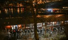 Des personnes font la queue pour passer la nuit sur l'Hermes, une péniche amarrée près de l'un des nombreux ponts qui enjambent la rivière Vltava à Prague, où le nombre de sans-abri connaît une augmentation inquiétante, le 26 janvier 2026 ( AFP / Michal Cizek )