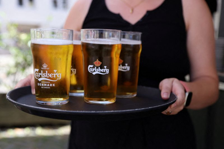 Un employé de bar porte un plateau de bière Carlsberg à Copenhague.