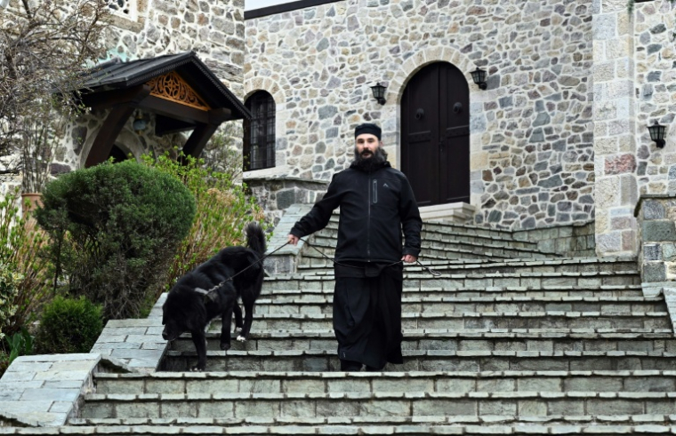 Le père Porfirij accompagné d'un chien Karaman au monastère Bigorski de Mavrovo i Rostuse, le 19 mars 2026 en Macédoine ( AFP / Robert ATANASOVSKI )