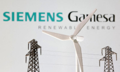 Des miniatures d'éoliennes et de poteaux électriques devant le logo de Siemens Gamesa