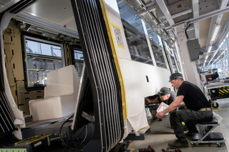 Des employés travaillent sur une ligne de production de tramway du constructeur ferroviaire CAF France, filiale du groupe espagnol CAF, à Bagnères-de-Bigorre, le 20 mai 2025 dans les Hautes-Pyrénées ( AFP / Matthieu RONDEL )