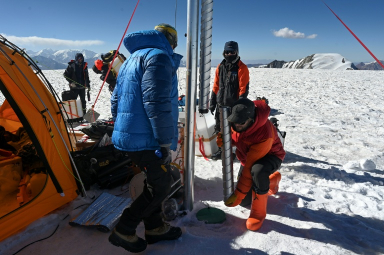 Le glaciologue Evan Miles (d) et le paléoclimatologue russe Stanislav Kutuzov (g) prélèvent une "carotte" de glace du glacier du Pamir dans le cadre de l'expédition "Pamir Ice Memory" le 24 septembre 2025 à Kon Tchoukourbachi, dans l'est du Tadjikistan ( AFP / Prakash MATHEMA )