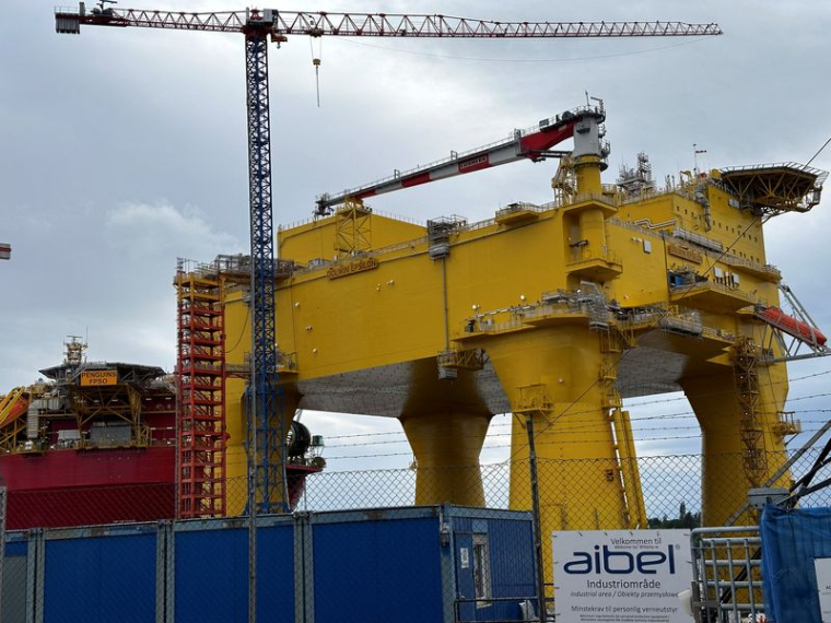 Un navire flottant de production pétrolière en mer et une plateforme éolienne offshore sont amarrés au chantier naval Aibel à Haugesund.