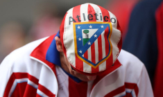 Un supporter de l'Atlético Madrid portant un chapeau avec l'écusson du club