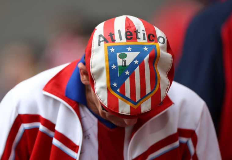 Un supporter de l'Atlético Madrid portant un chapeau avec l'écusson du club