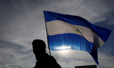 Une personne brandit un drapeau national nicaraguayen lors d'une manifestation à Managua